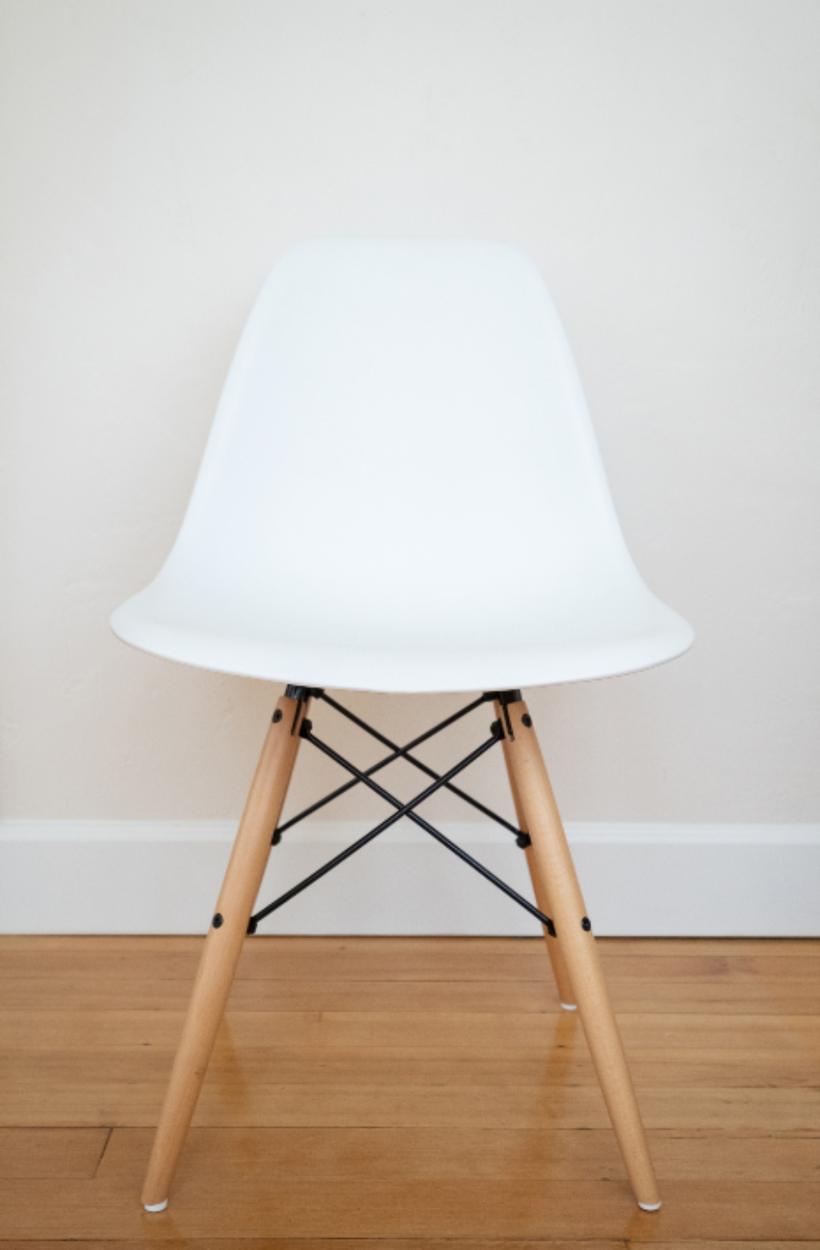 A finished room with a chair against a plain painted wall