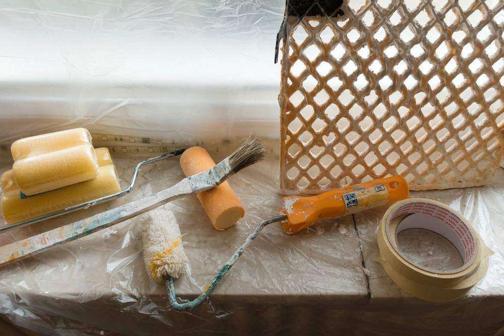 Brushes, rollers and tape laid out ready on a drop cloth