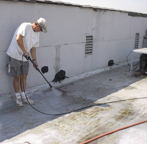 A flat roof being washed down before any coating goes on